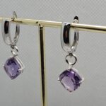 Hõbedast inglise lukuga kõrvarõngad. Luku küljas ripub ametüst romb, mis on ääristatud hõbedaga