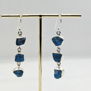 Kolme pooltöödeldud toorkiviga, erksinise apatiidiga ketina alla rippuvad konksuga hõbekõrvarõngad